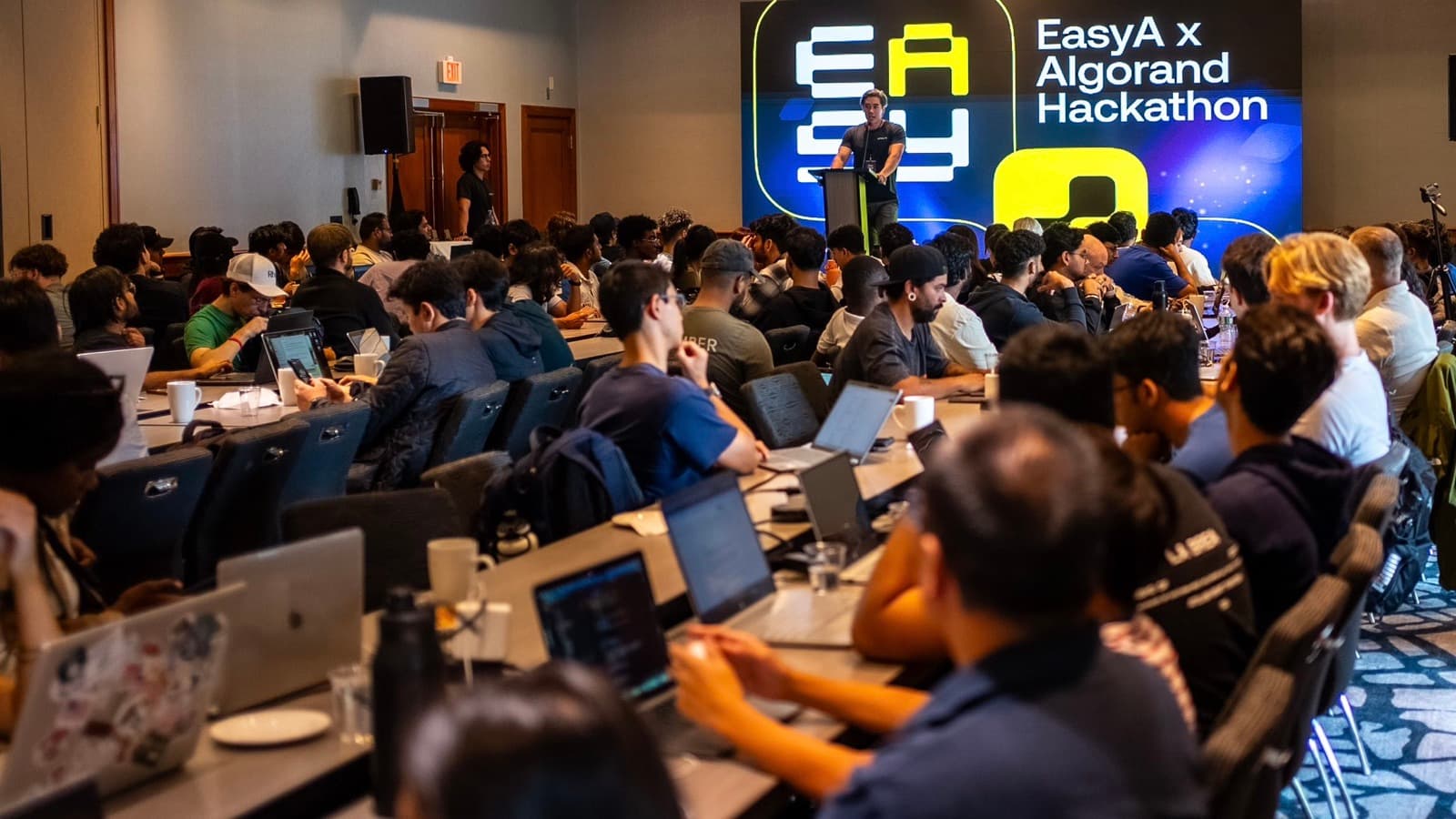 A packed room of builders at the EasyA × Algorand hackathon, Charles among them